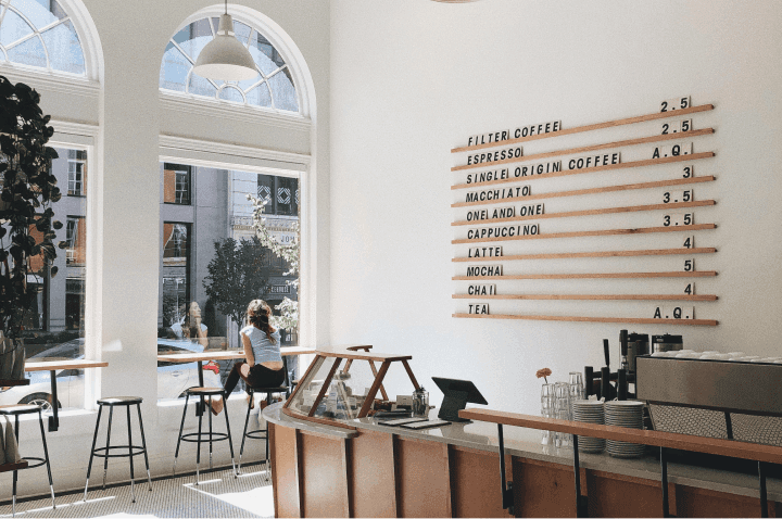 Woman staring out of a window inside a specialty coffee place